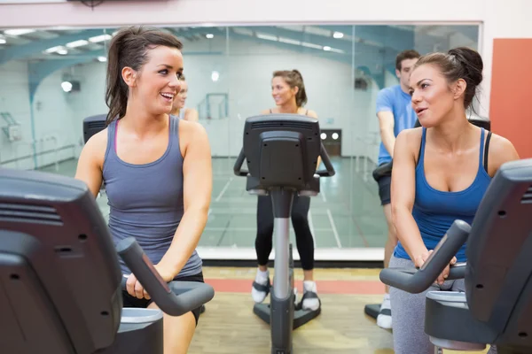 Due donne che parlano mentre si allenano in una classe di spinning — Foto Stock