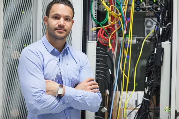 Man die met gekruiste in datacenter armen — Stockfoto