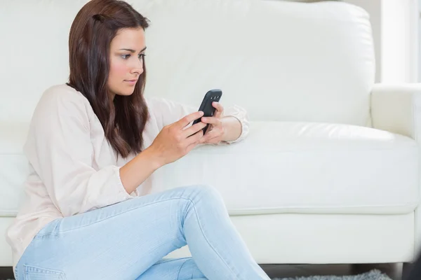 Brunette vrouw texting met haar mobiele telefoon — Stockfoto