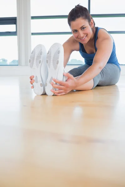 Glad kvinna stretching benen — Stockfoto