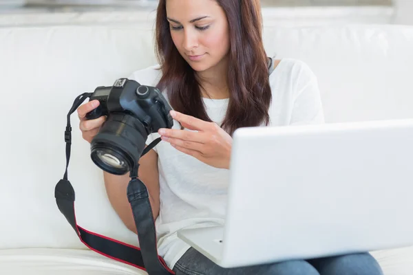 Mulher segurando um laptop e uma câmera — Fotografia de Stock