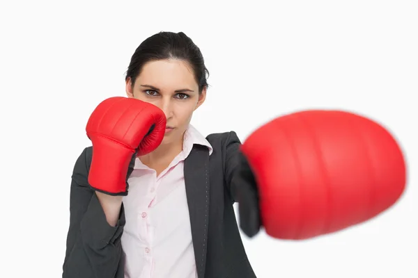 Ernstige vrouw draagt rode handschoenen ponsen — Stockfoto