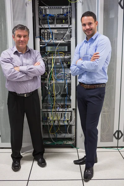 Dos técnicos de pie frente a los servidores — Foto de Stock