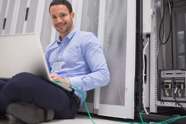 Técnico feliz trabajando en el ordenador portátil conectado al servidor —  Fotos de Stock