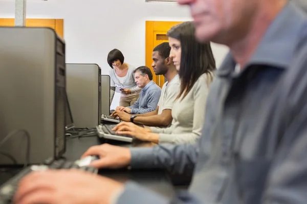 Teacher helping her students in computer class — Stock Photo, Image