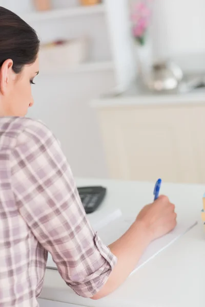 Frau schreibt auf Notizblock — Stockfoto