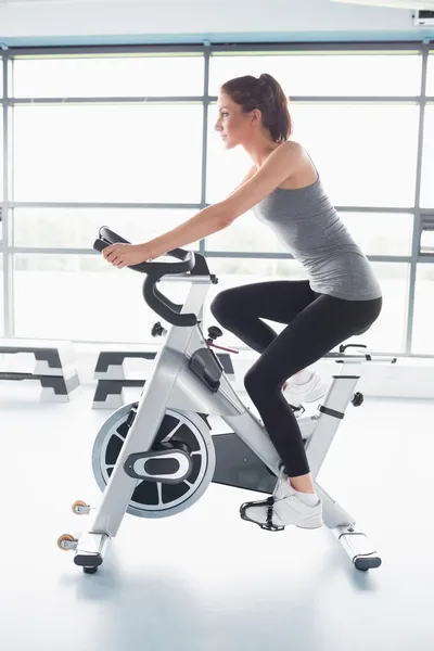 Frau fährt energisch Heimtrainer — Stockfoto