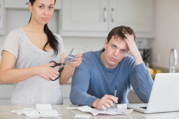 Pareja decepcionada en la cocina cortando tarjeta de crédito —  Fotos de Stock