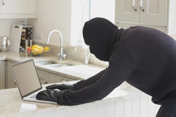 Robber using laptop — Stock Photo, Image