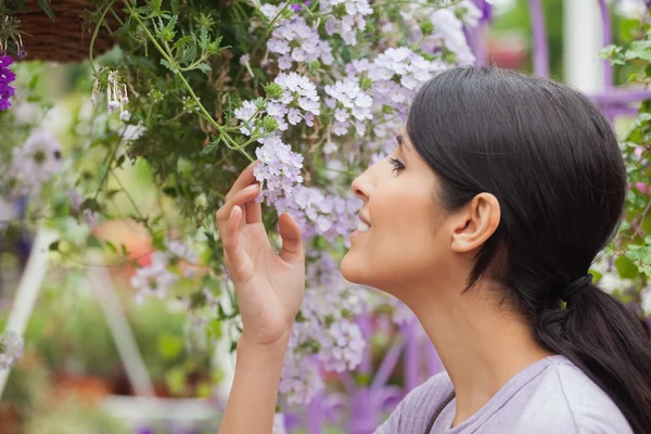 女人嗅到的同时拿一朵花 — 图库照片