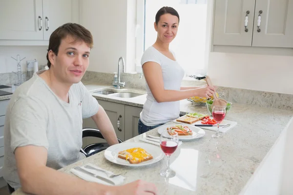 Happy couple having lunch in kitchen — Stock Photo, Image