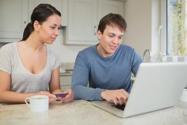 Man showing woman something on laptop — Stock Photo, Image