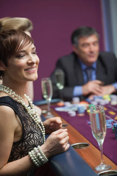 Woman smiling and waiting for roulette wheel — Stock Photo, Image