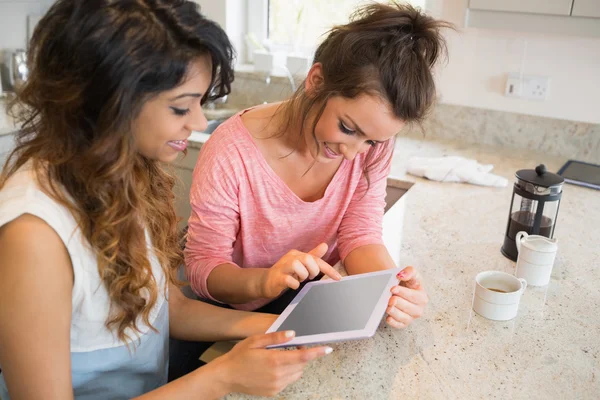 Happy friends looking at tablet computer and having coffee — Stock Photo, Image