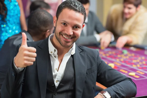 Smiling an thumbs up at roulette table — Stock Photo, Image