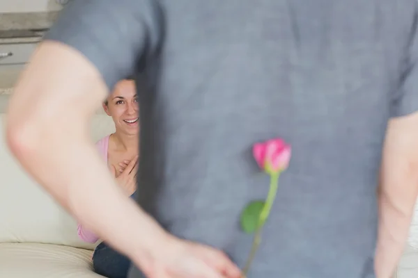 Manžel skrývá květ za zády — Stock fotografie