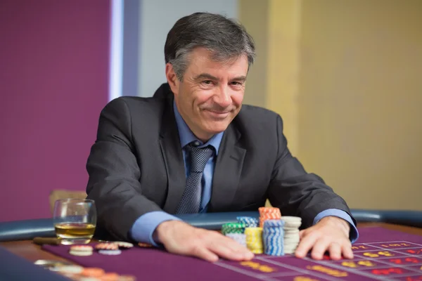 Man smiling and taking his chips — Stock Photo, Image