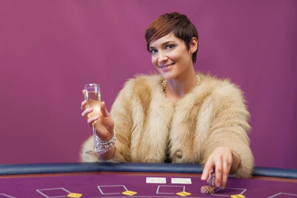 Femme avec champagne à la table de poker — Photo