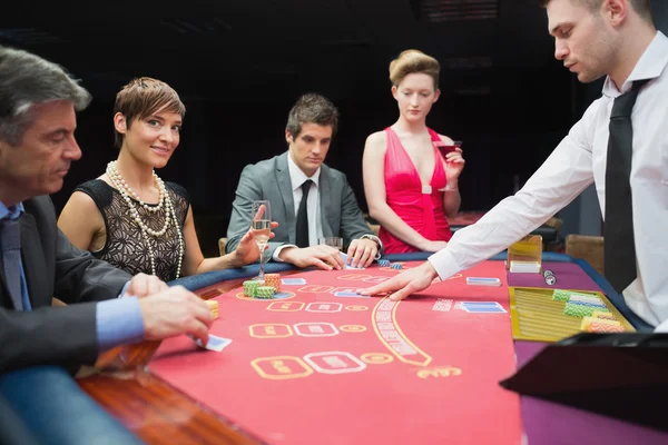 Mulher olhando para cima do jogo de poker e sorrindo — Fotografia de Stock