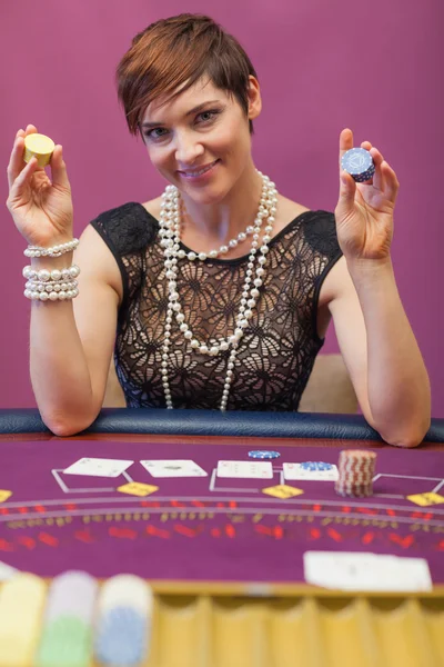 Woman holding chips in her hand in a casino — Stock Photo, Image