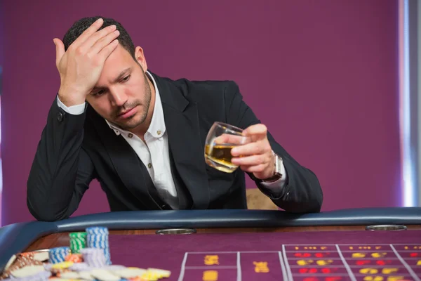 Man looking at whiskey glass — Stock Photo, Image