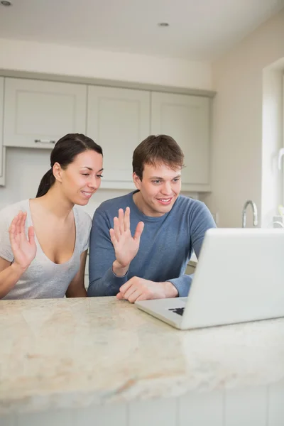 Casal sorrindo usando bate-papo de vídeo no laptop — Fotografia de Stock