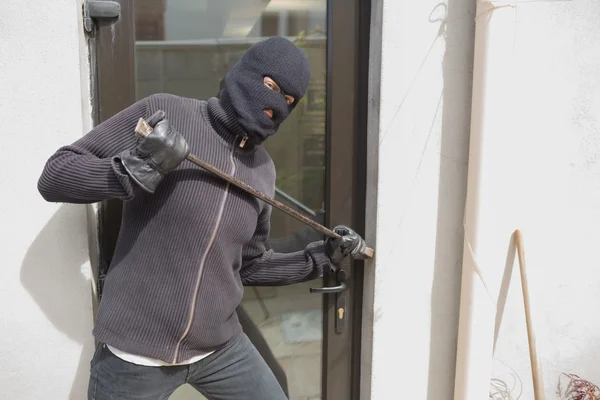 Robber entrant par effraction dans la maison en utilisant corbeau bar — Photo