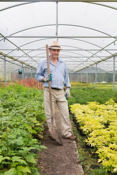 Gardener holding a spade while smiling — Stock Photo, Image