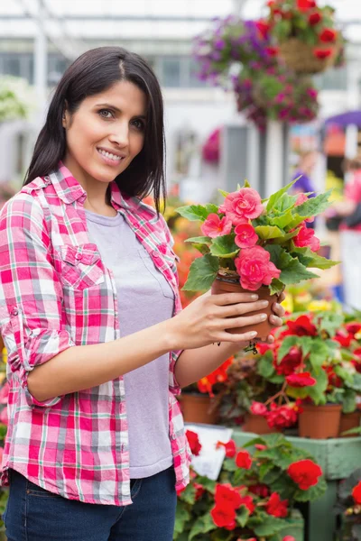Улыбающаяся женщина, держащая цветок — стоковое фото