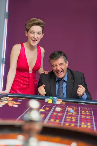 Man and woman cheering at roulette table — Stock Photo, Image