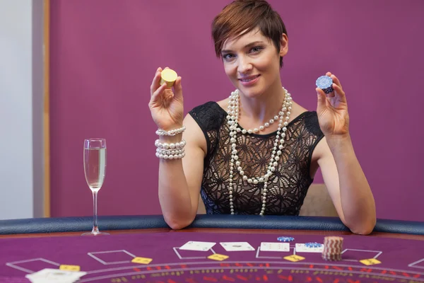 Woman at poker game holding up chips — Stock Photo, Image