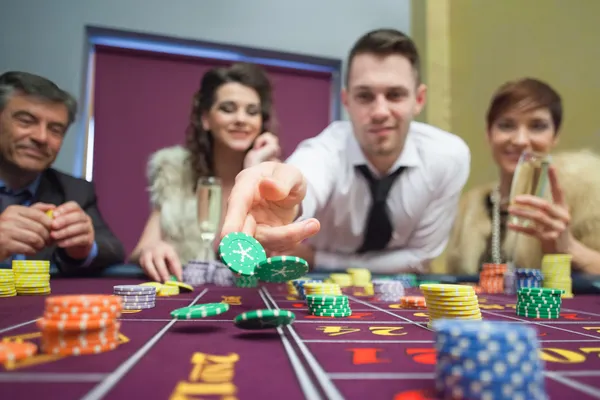 Hombre lanzando fichas abajo en la mesa de ruleta —  Fotos de Stock