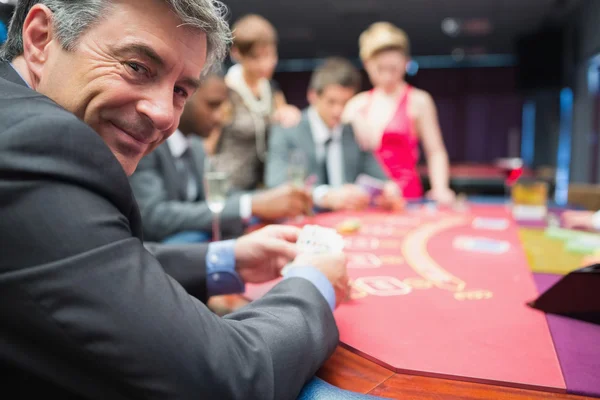 Человек улыбается за покерным столом — стоковое фото