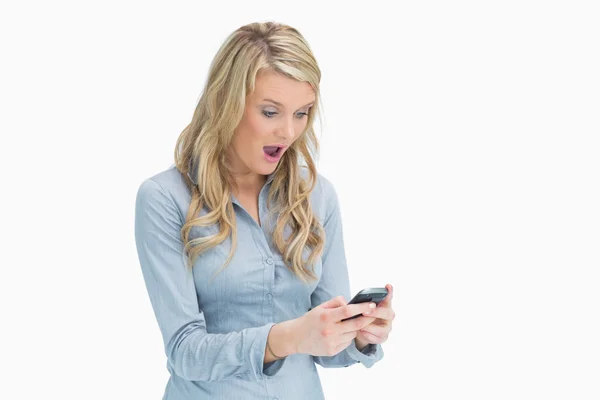 Kvinna som tittar förvånad på sin smartphone — Stockfoto