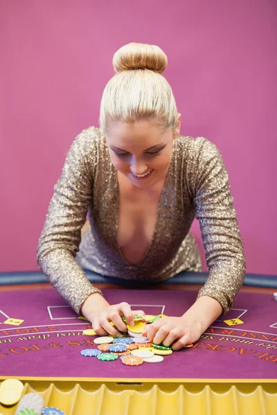 Woman in a casino grabbing chips — Stock Photo, Image