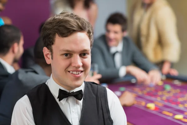 Återförsäljare står vid roulettebordet — Stockfoto