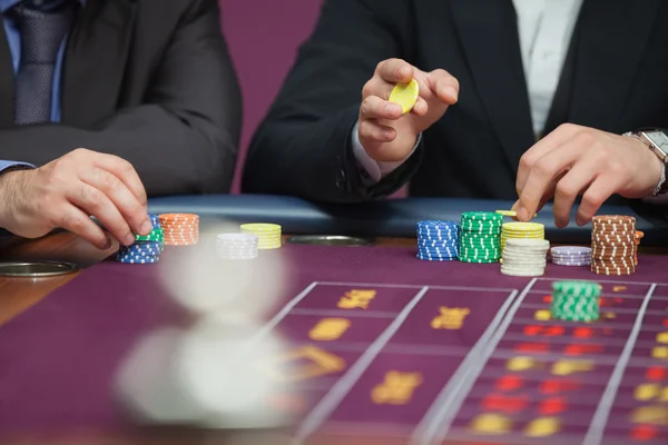 Due uomini che piazzano scommesse sulla roulette — Foto Stock