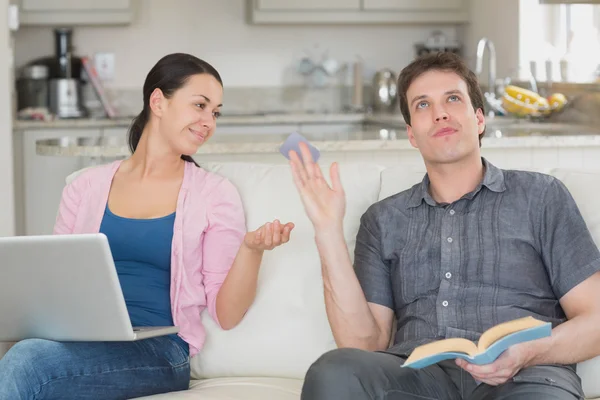 Casal relaxante com um laptop e um livro — Fotografia de Stock