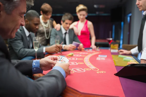 Человек счастливо смотрит на свою покерную руку — стоковое фото