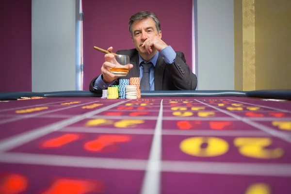 Muž sedící u stolu rulety — Stock fotografie