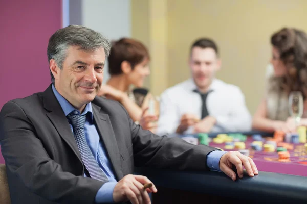 Man with cigar taking break from roulette table — Stock Photo, Image