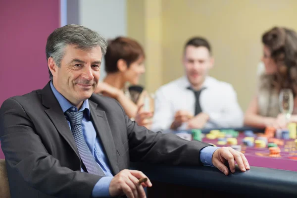 Hombre con cigarro tomando un descanso de la mesa de ruleta —  Fotos de Stock