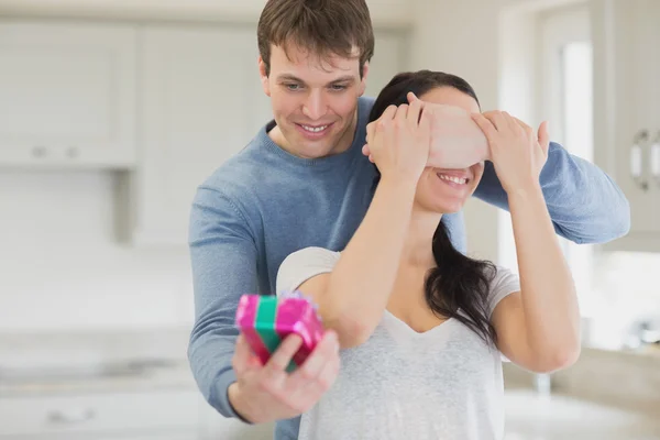 Husband surprising wife with gift — Stock Photo, Image