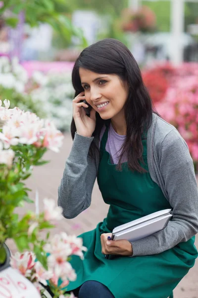 Mitarbeiterin macht Bestandsaufnahme bei Anruf im Gartencenter — Stockfoto