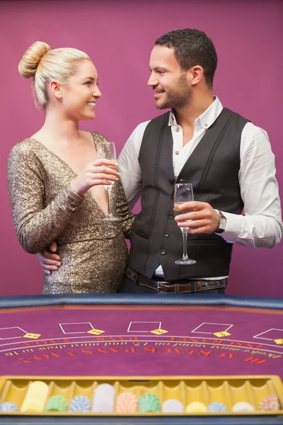 Couple drinking champagne at poker table — Stock Photo, Image