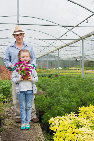 Liten flicka håller flower pot stående med hennes farfar — Stockfoto