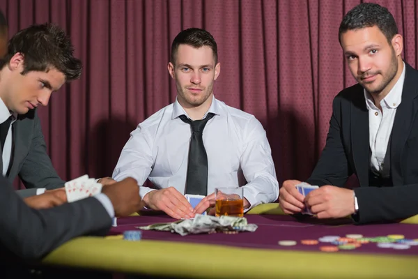 Två leende män tittar upp från pokerspel — Stockfoto