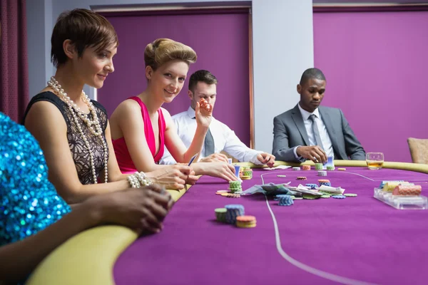 Sitting at the casino table smiling — Stock Photo, Image