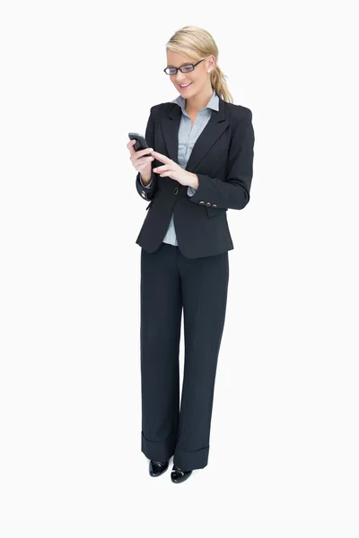 Kobieta stojąc i przy użyciu telefonu komórkowego — Zdjęcie stockowe