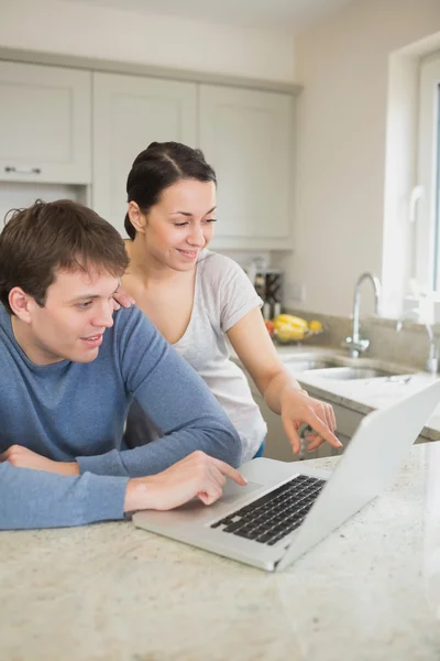 Happy couple looking at laptop — Stock Photo, Image